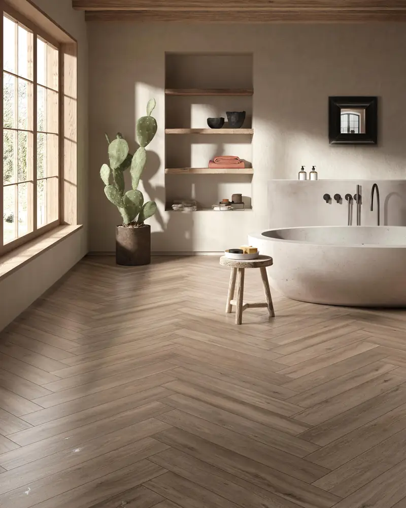 Bathroom with a freestanding bath and a wood-effect floor laid in herringbone
