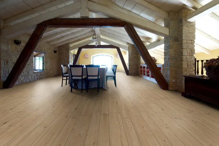 Attic room with exposed beams and a light wood-effect floor